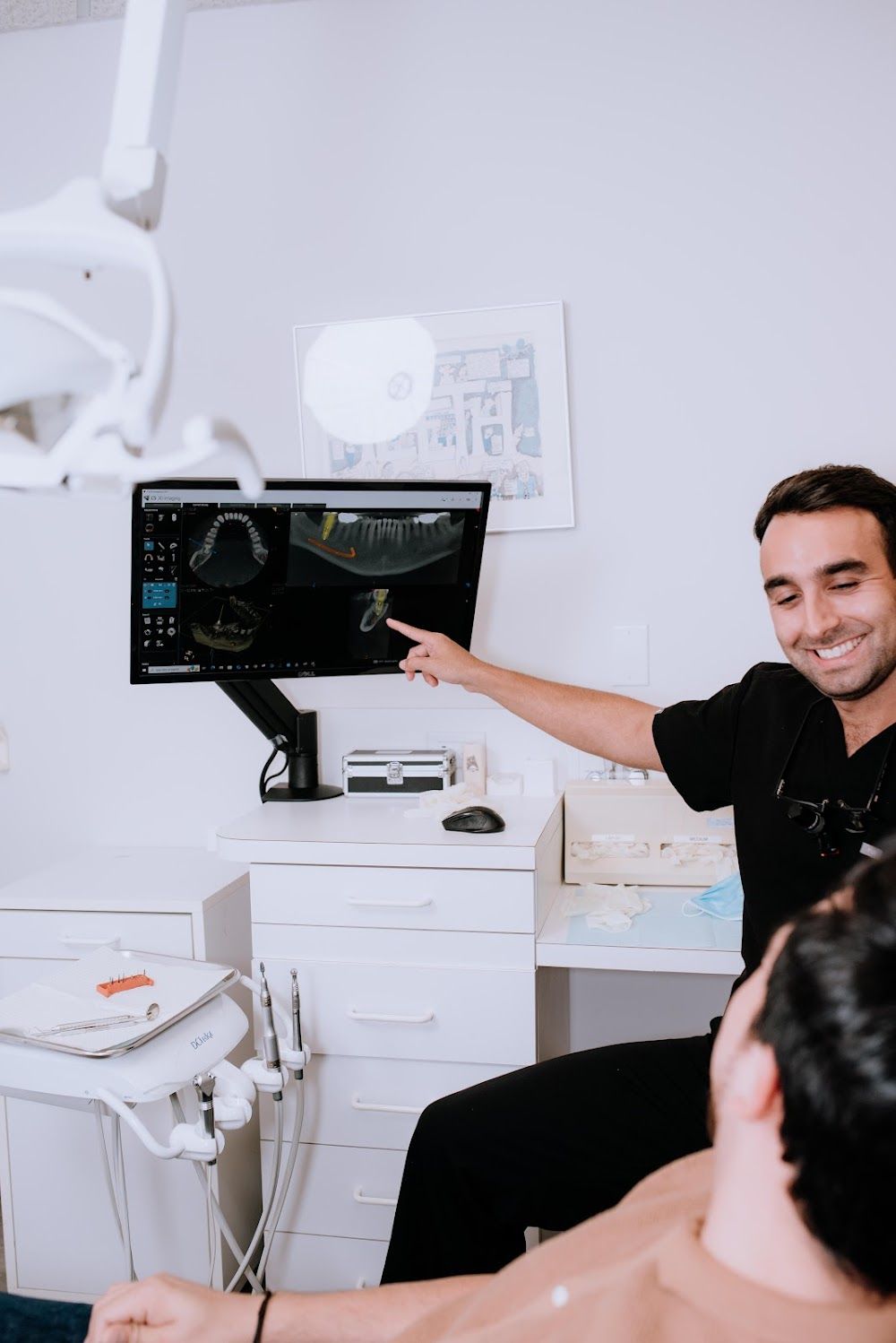 Periodontist reviewing a 3D CBCT scan with a patient